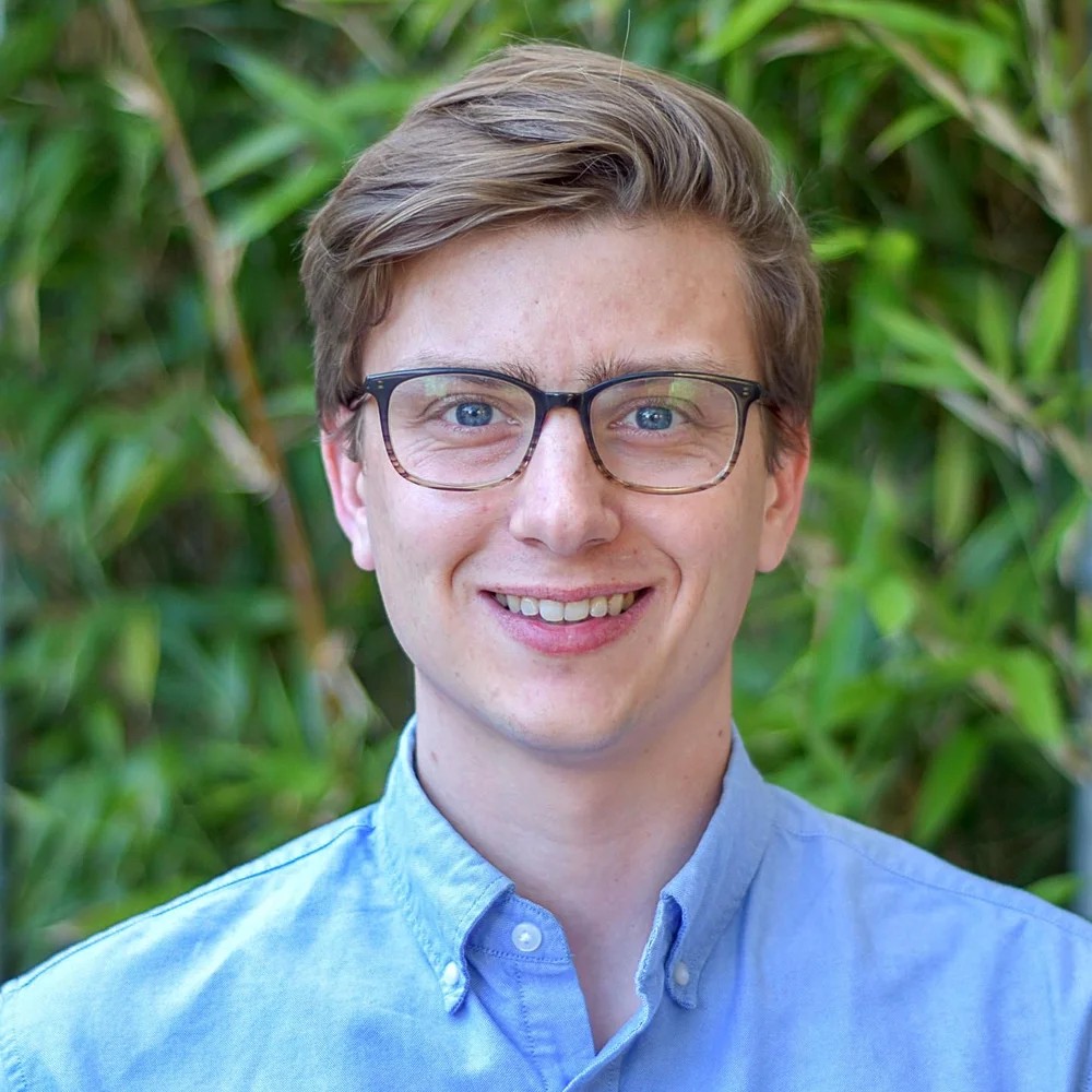 Chris Baehr in a lab holding a sample tube.